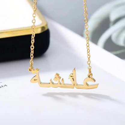 Gold custom Arabic name necklace hanging elegantly, displayed against a white and black background, showcasing personalized jewelry design for unique fashion accessories.