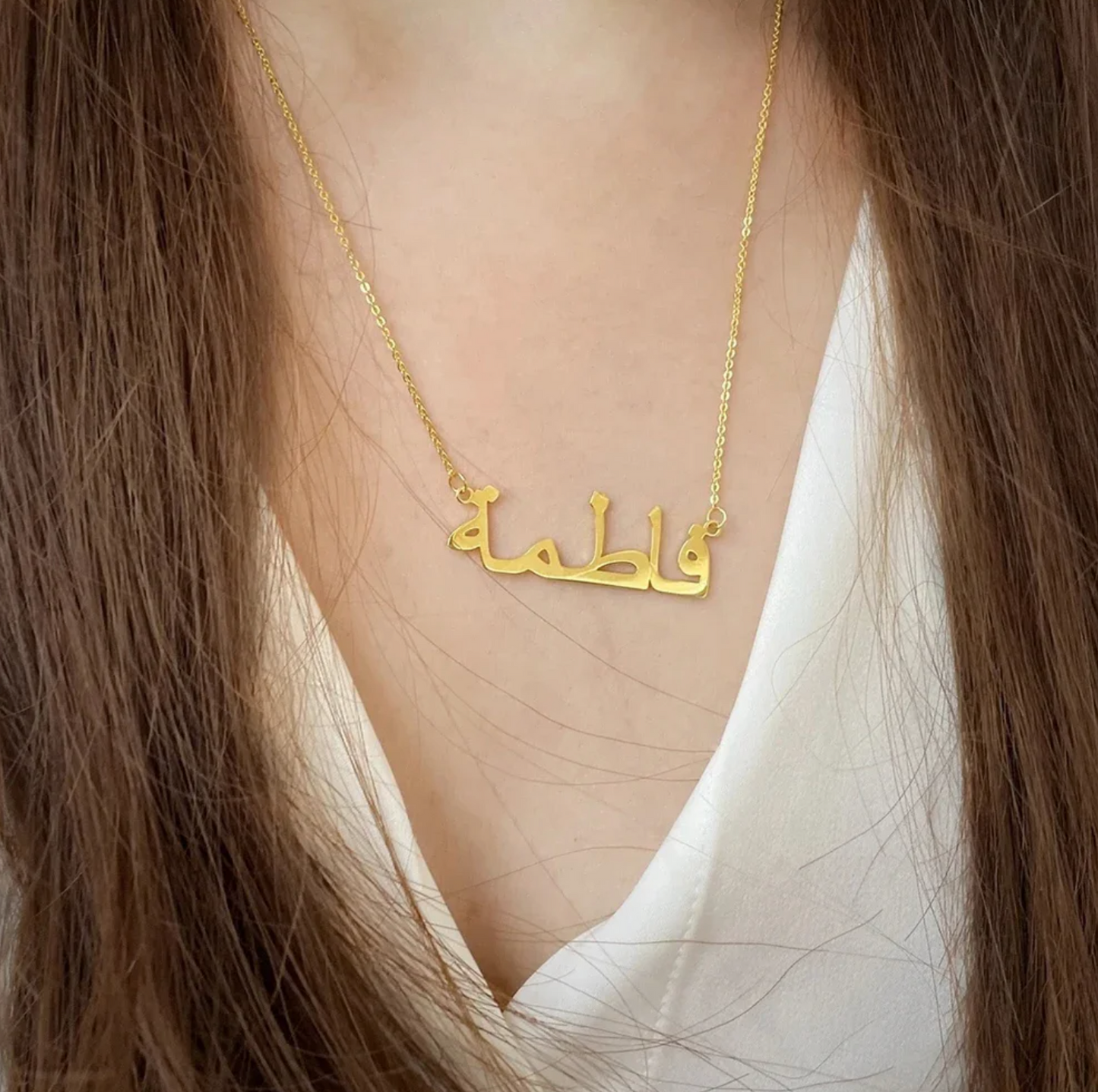 Closeup of a woman wearing a custom Arabic name necklace in gold, highlighting personalized jewelry design for stylish and unique fashion accessories.