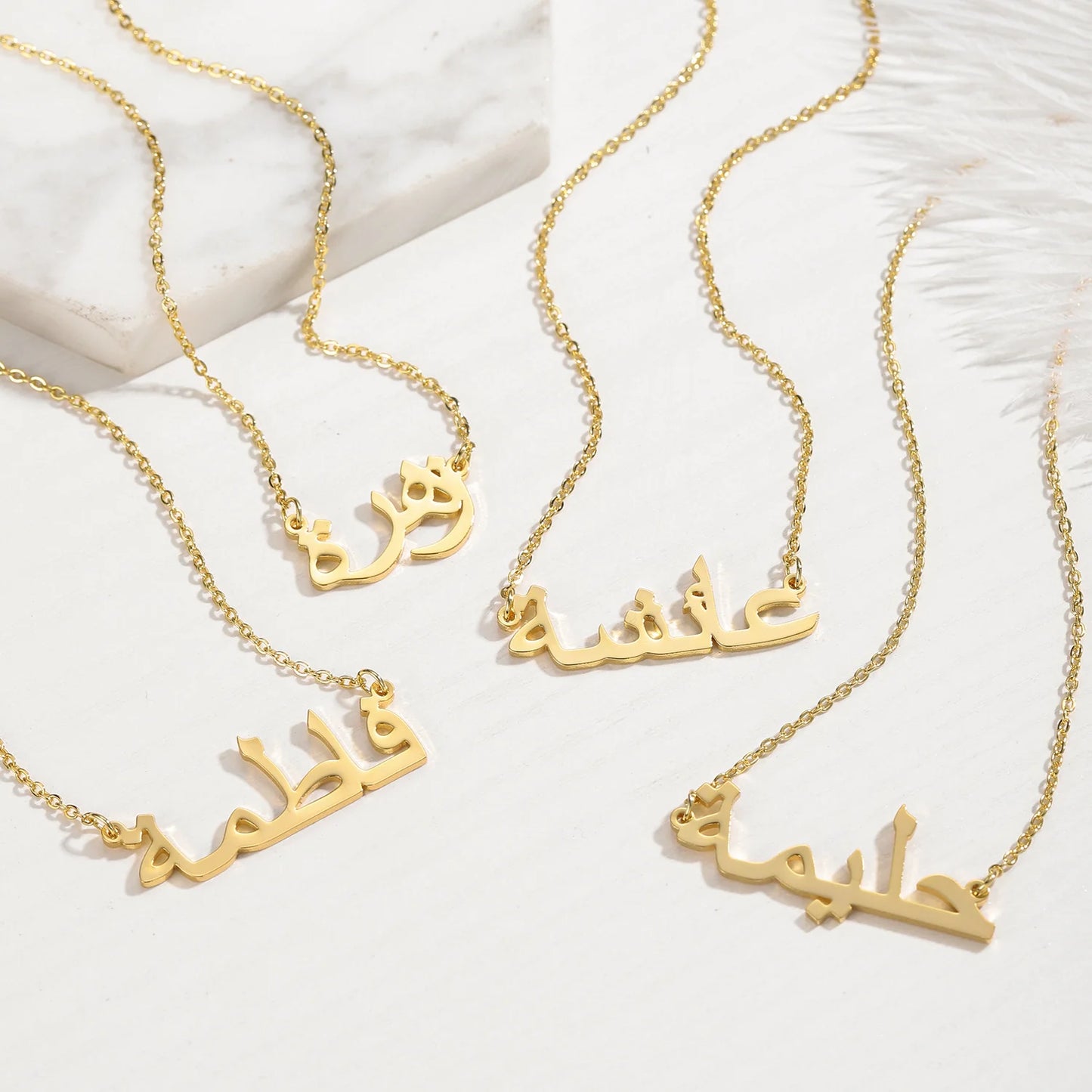 Collection of custom Arabic name necklaces in gold, featuring multiple names elegantly displayed on a white background, showcasing personalized jewelry design for unique fashion accessories.