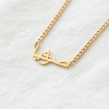 Gold tone custom Arabic script pendant necklace on curb chain close up