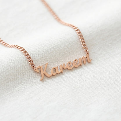 Rose gold tone English script name necklace reading Kareem on curb chain close up